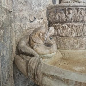 A stone dolphin on a fountain