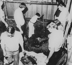 A crime scene from 1973 with a large crowd and no one wearing PPE. 
