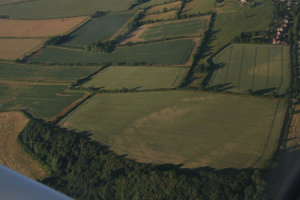 An aerial photograph showing patches of scorched crops in a field
